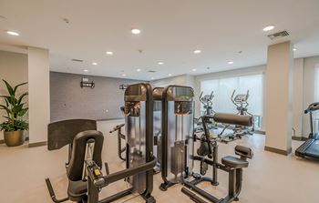 a gym with cardio equipment on the floor and a window